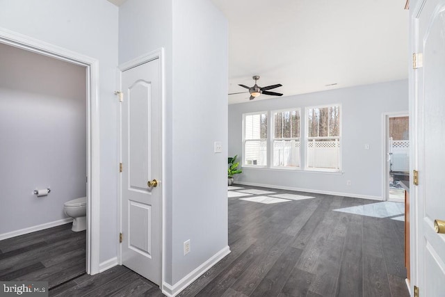 hallway featuring dark wood finished floors and baseboards