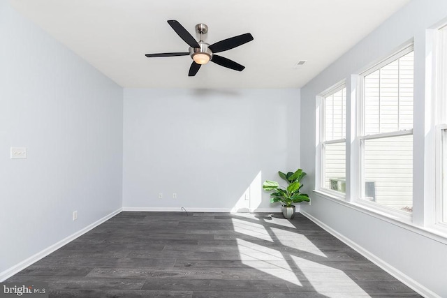 unfurnished room featuring dark wood-style floors, ceiling fan, and baseboards