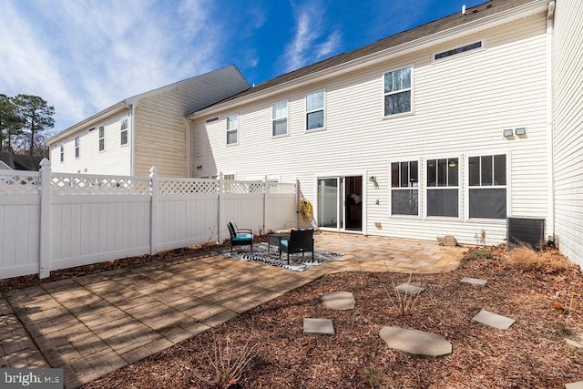 rear view of property with cooling unit, a patio area, and fence