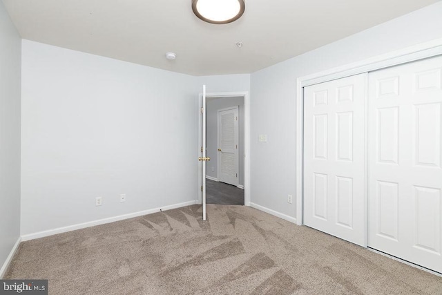 unfurnished bedroom featuring a closet, carpet flooring, and baseboards