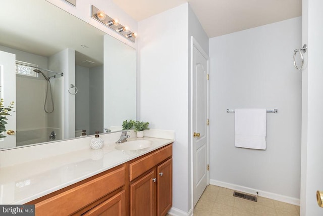 bathroom featuring tile patterned floors, visible vents, washtub / shower combination, baseboards, and vanity