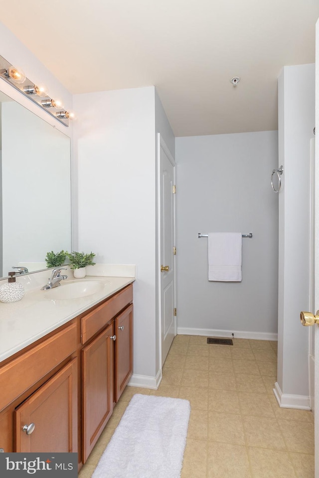 bathroom featuring visible vents, baseboards, and vanity