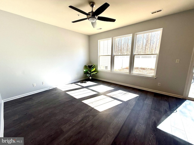 empty room featuring visible vents, baseboards, and wood finished floors