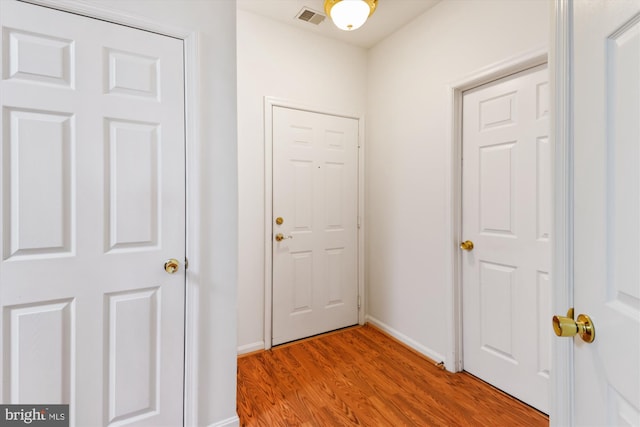 entryway featuring baseboards, visible vents, and light wood finished floors