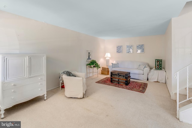 carpeted living area featuring stairs