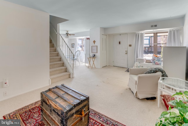 carpeted living room with visible vents and stairs