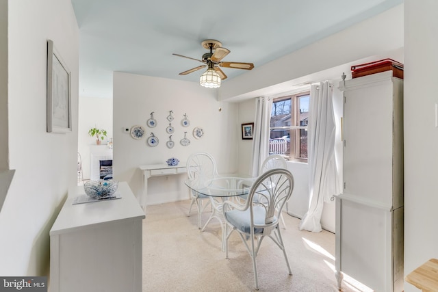 dining room with light carpet and a ceiling fan