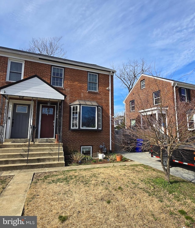 view of front of home featuring brick siding and a front lawn