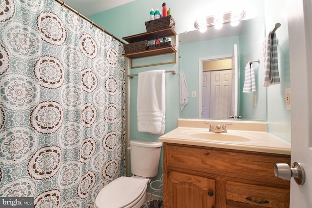 full bathroom featuring a shower with shower curtain, toilet, and vanity