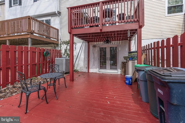 wooden deck featuring cooling unit, french doors, and a fenced backyard