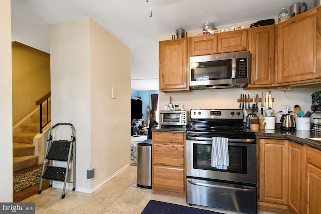 kitchen featuring dark countertops, a toaster, brown cabinetry, and stainless steel appliances