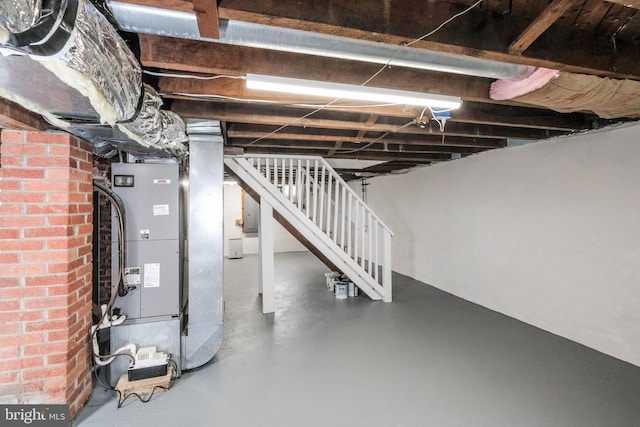 unfinished basement with stairway, heating unit, and electric panel