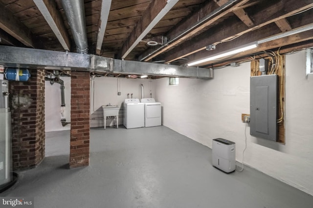 unfinished basement featuring independent washer and dryer, a sink, and electric panel