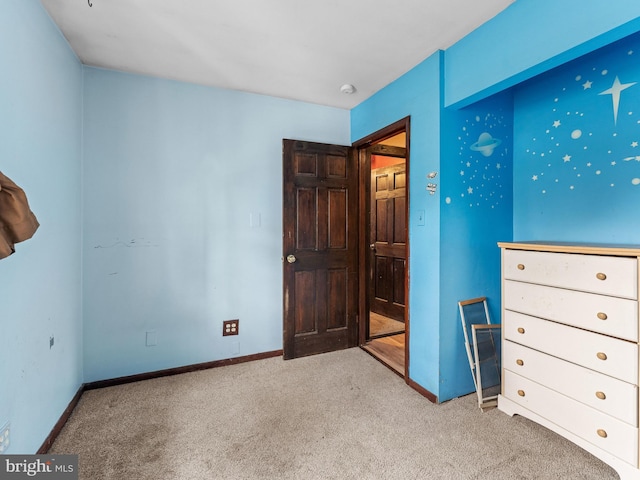 unfurnished bedroom featuring carpet and baseboards