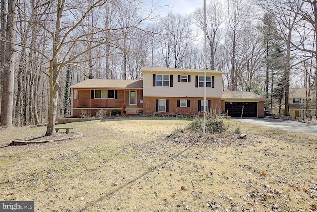 tri-level home featuring brick siding, an attached garage, and driveway