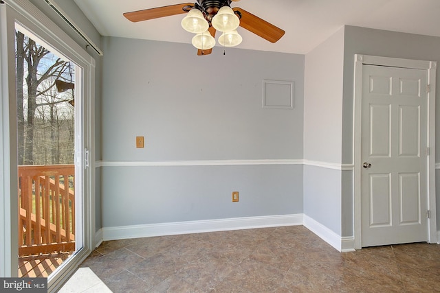 empty room featuring baseboards and ceiling fan