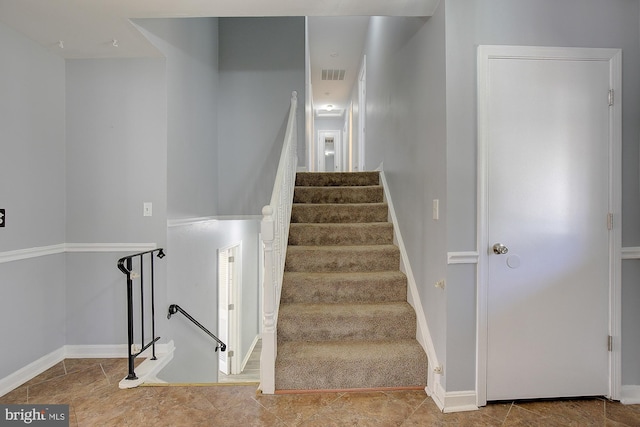 stairway featuring visible vents and baseboards