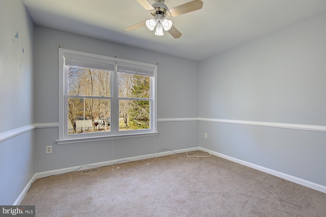 unfurnished room featuring carpet flooring, ceiling fan, baseboards, and visible vents