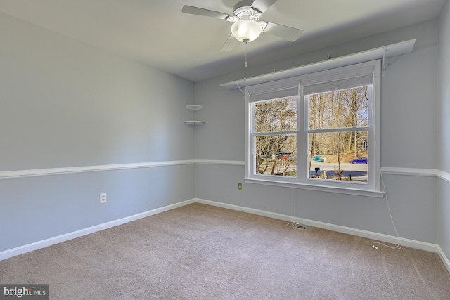 empty room with carpet flooring, a ceiling fan, and baseboards