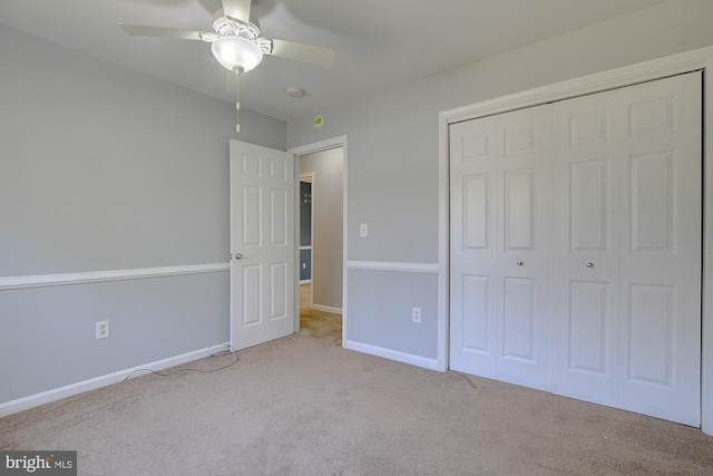 unfurnished bedroom with a closet, baseboards, carpet, and a ceiling fan