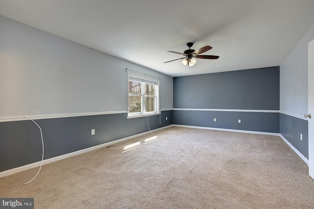 carpeted empty room featuring visible vents, ceiling fan, and baseboards