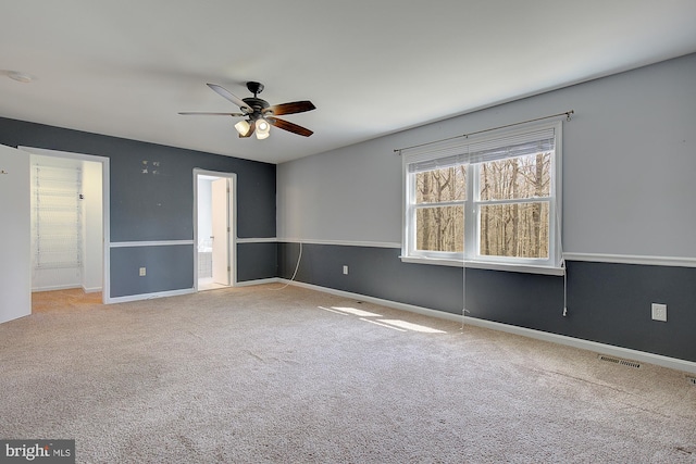 unfurnished bedroom featuring baseboards, visible vents, ceiling fan, carpet flooring, and connected bathroom