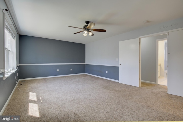 spare room featuring a ceiling fan, baseboards, and carpet floors