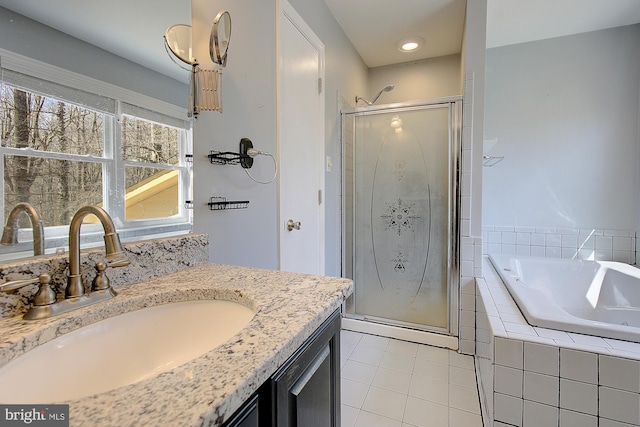 bathroom featuring vanity, a shower stall, a bath, and tile patterned floors