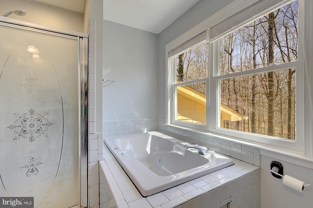 full bathroom featuring a jetted tub, a healthy amount of sunlight, and a stall shower