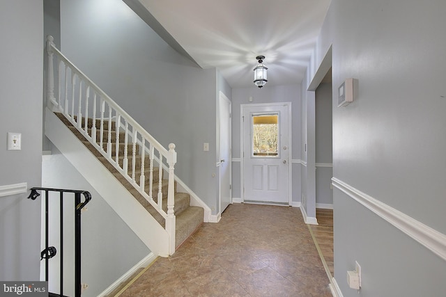 entrance foyer with stairway and baseboards