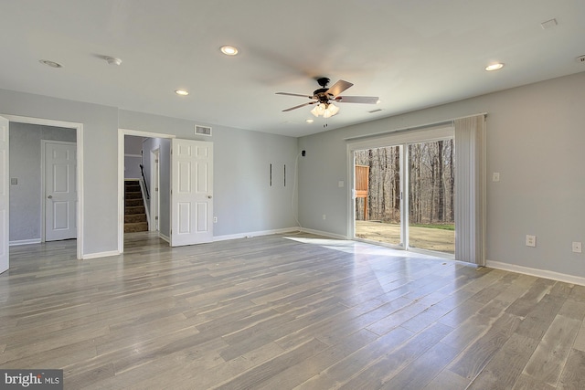 spare room featuring wood finished floors, visible vents, and baseboards