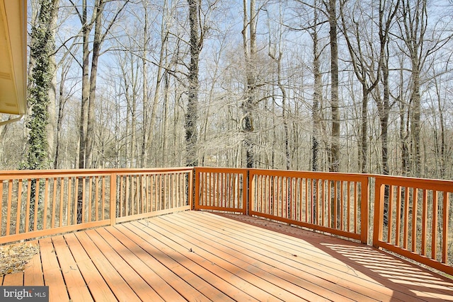 wooden terrace featuring a forest view