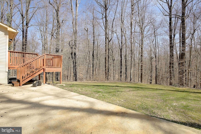 view of yard featuring a patio area, a wooden deck, and stairs