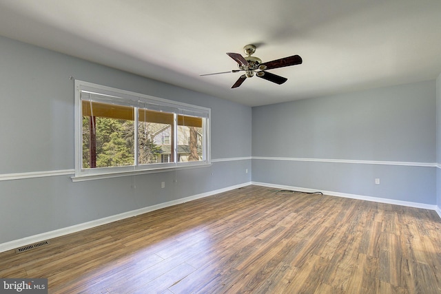 unfurnished room with visible vents, baseboards, and dark wood-style floors