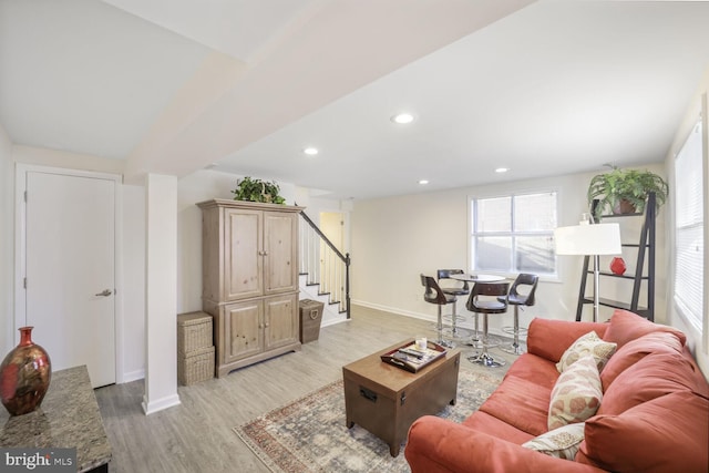 living room featuring stairs, light wood-type flooring, baseboards, and recessed lighting