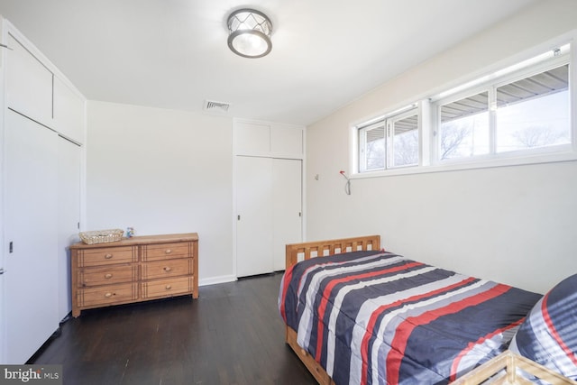 bedroom featuring visible vents and wood finished floors