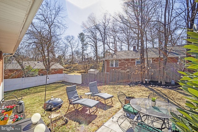 view of yard with outdoor dining space, a patio area, and a fenced backyard