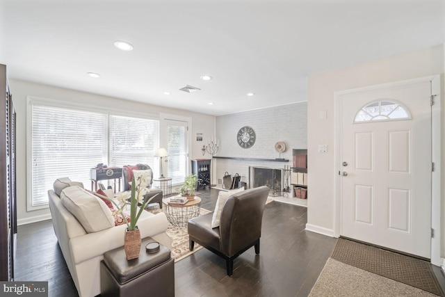 living area featuring a fireplace, visible vents, dark wood-type flooring, and recessed lighting