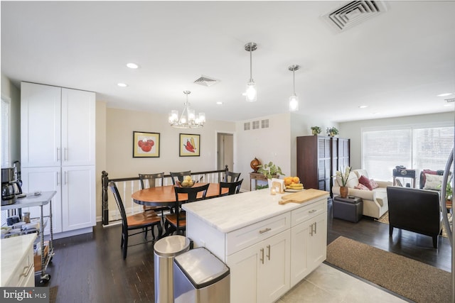 kitchen featuring light countertops, white cabinets, and visible vents