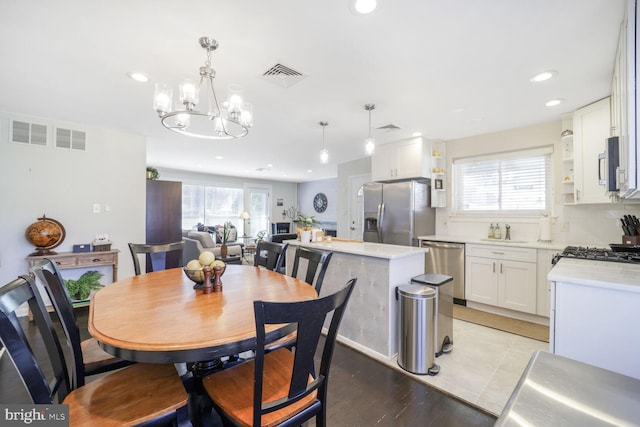 dining space featuring light wood finished floors, visible vents, and recessed lighting