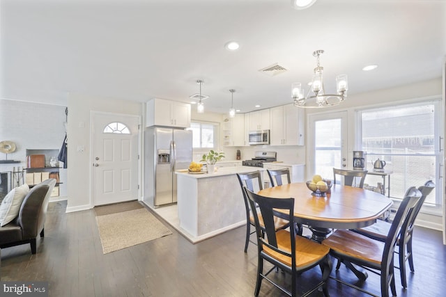 dining space featuring an inviting chandelier, wood finished floors, visible vents, and recessed lighting