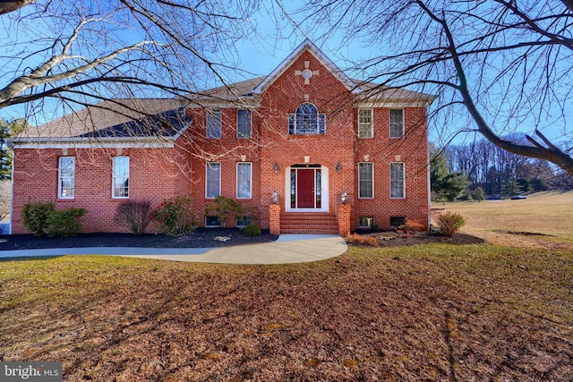 colonial house with brick siding and a front lawn