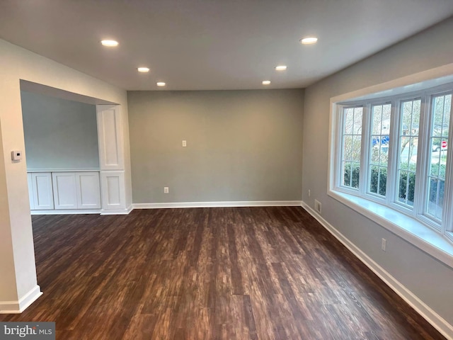 unfurnished room with baseboards, dark wood-style flooring, and recessed lighting