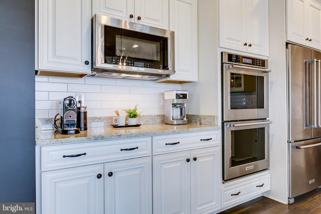 kitchen with white cabinetry, tasteful backsplash, and stainless steel appliances