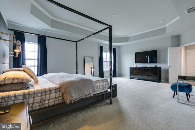 bedroom with visible vents, carpet flooring, a raised ceiling, and multiple windows