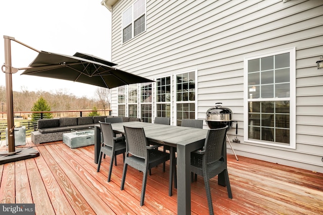 wooden deck with an outdoor living space with a fire pit and outdoor dining space