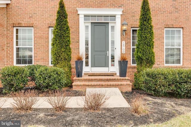 doorway to property featuring brick siding