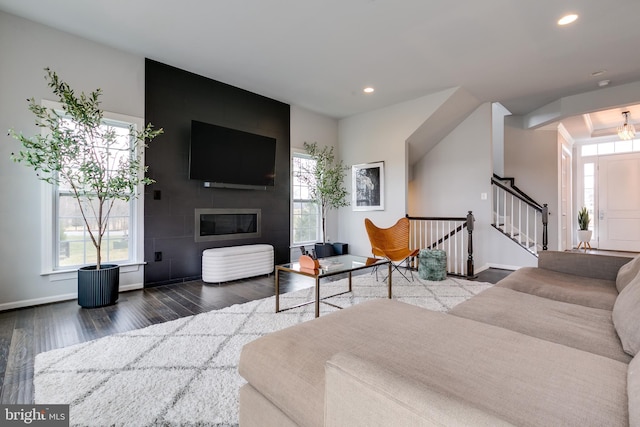 living room featuring recessed lighting, a fireplace, a healthy amount of sunlight, and wood finished floors