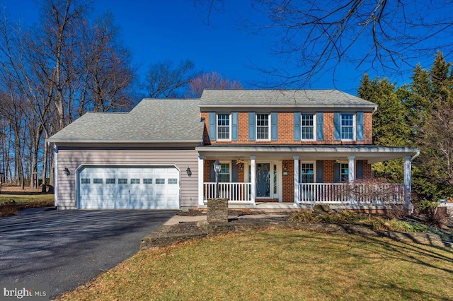 view of front facade featuring brick siding, an attached garage, a porch, a front yard, and driveway