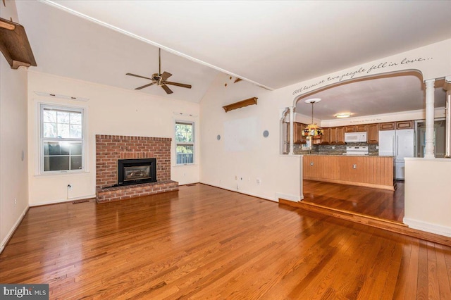 unfurnished living room with hardwood / wood-style floors, vaulted ceiling, and a wealth of natural light